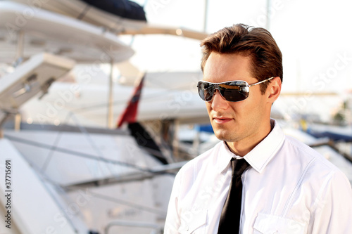 Portrait of Casual man wearing sunglasses, over yacht outdoors
