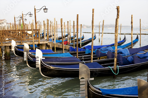 Gondolas tied to wooden poles in Venice, Italy © Sara Leban