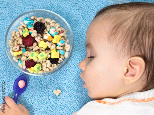 Tired baby sleeping beside full bowl of cereal