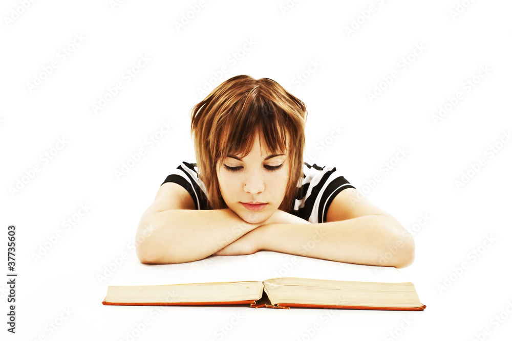 Teenage girl sitting at the desk and reading book Teenage girl sitting at the desk and reading book