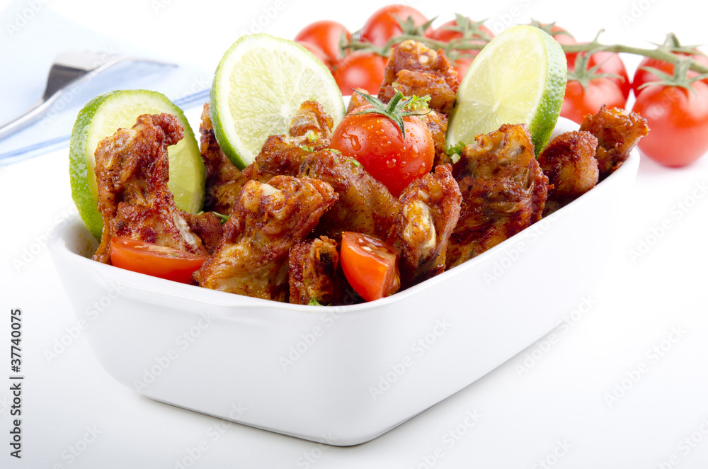 Fotografie gegrillte Hühnerschenkel in einer Schale mit Tomate
