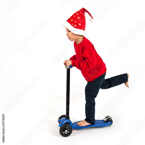 Kid with christmas hat and scooter on white background.