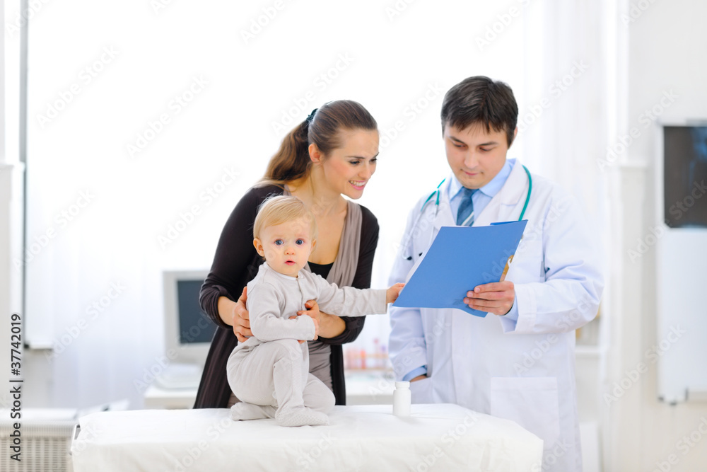 Baby touching card while pediatrician talking with mother