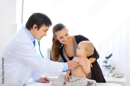 Surprised baby being checked by a doctor using a stethoscope