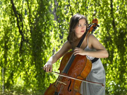 Cello Spielerin vor Baum