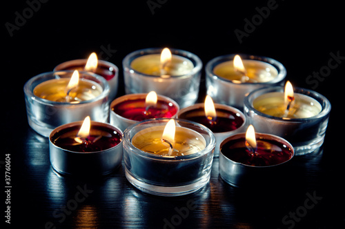 Close-up of tea light candles burning in the darkness