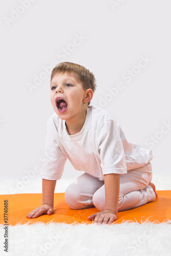 Children's yoga. The little boy does exercise.