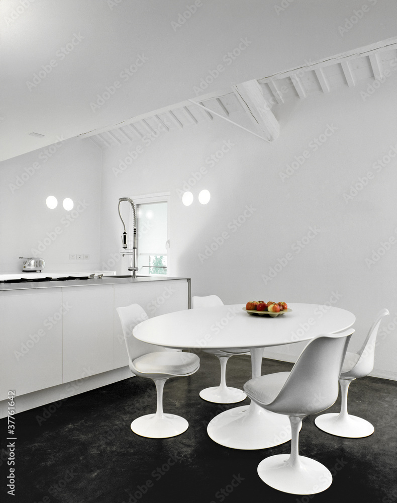 Foto Stock sedie bianche intorno al tavolo ovale in cucina moderna