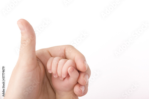 Close-up of baby's hand holding mother's finger