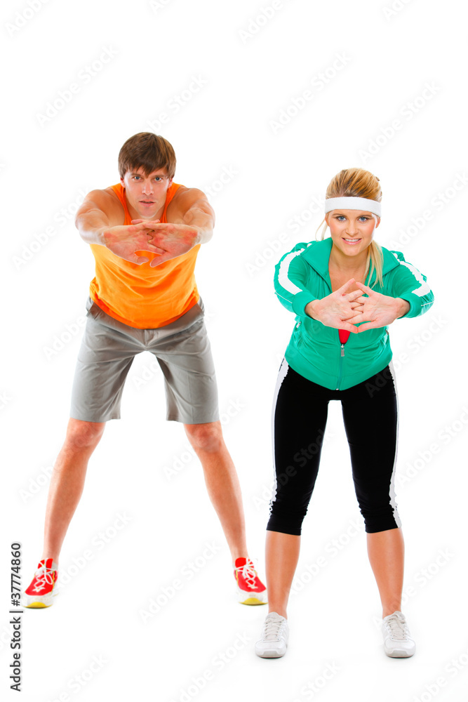 Fit young woman and man in sportswear making sport exercise Fit young woman and man in sportswear making sport exercise
