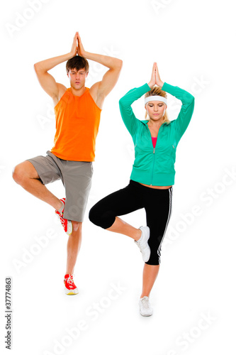 Fitness girl and man in sportswear doing yoga isolated on white