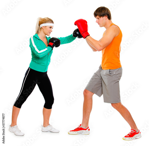 Young woman and man in boxing gloves practicing