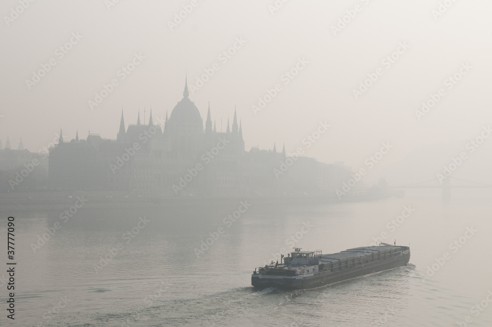 Budapest parliament in smog with a ship
