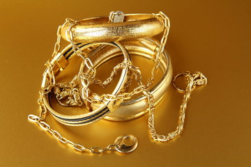 gold jewelry, bracelets and chains  on gold background