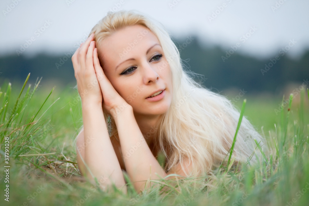 Naklejka premium young woman laying in the grass