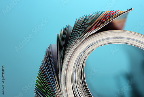 Rolled up magazines on blue background photo