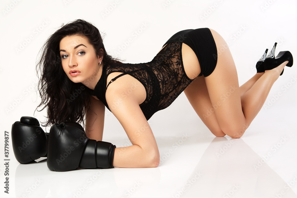 A young woman boxer in black boxing gloves.