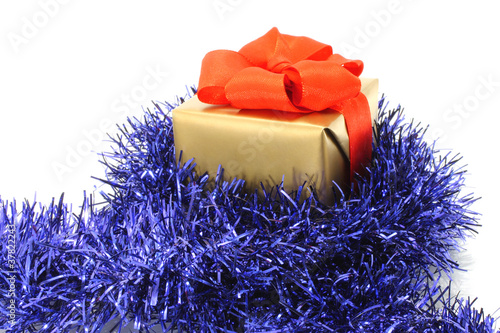 Gold gift box with blue tinsel on white background