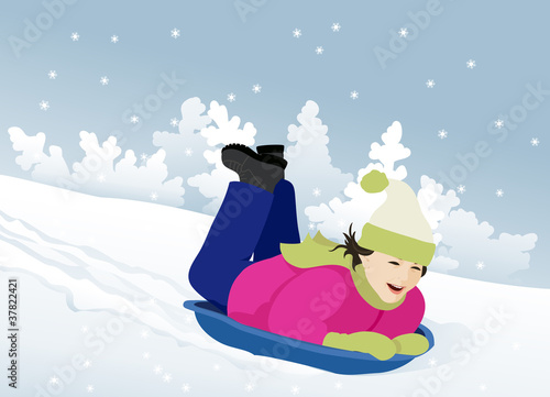 Little girl sledding in the snow slope