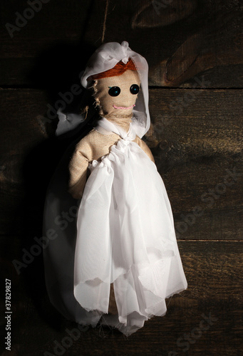 Hanged doll voodoo girl-bride on wooden background