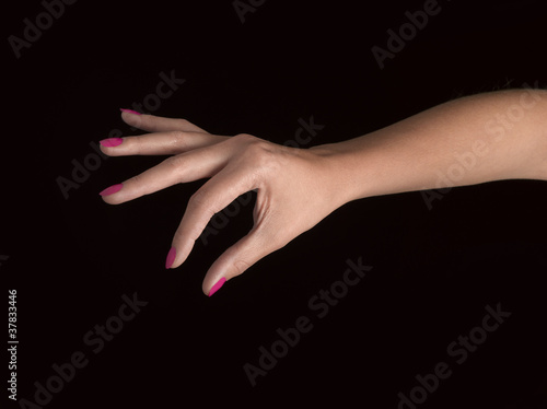 Close-up of beautiful woman's hand, taking something. Black back