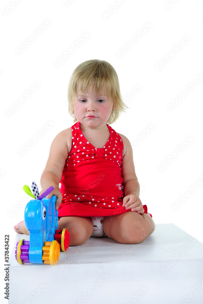 The small beautiful girl plays a white background The small beautiful girl plays a white background