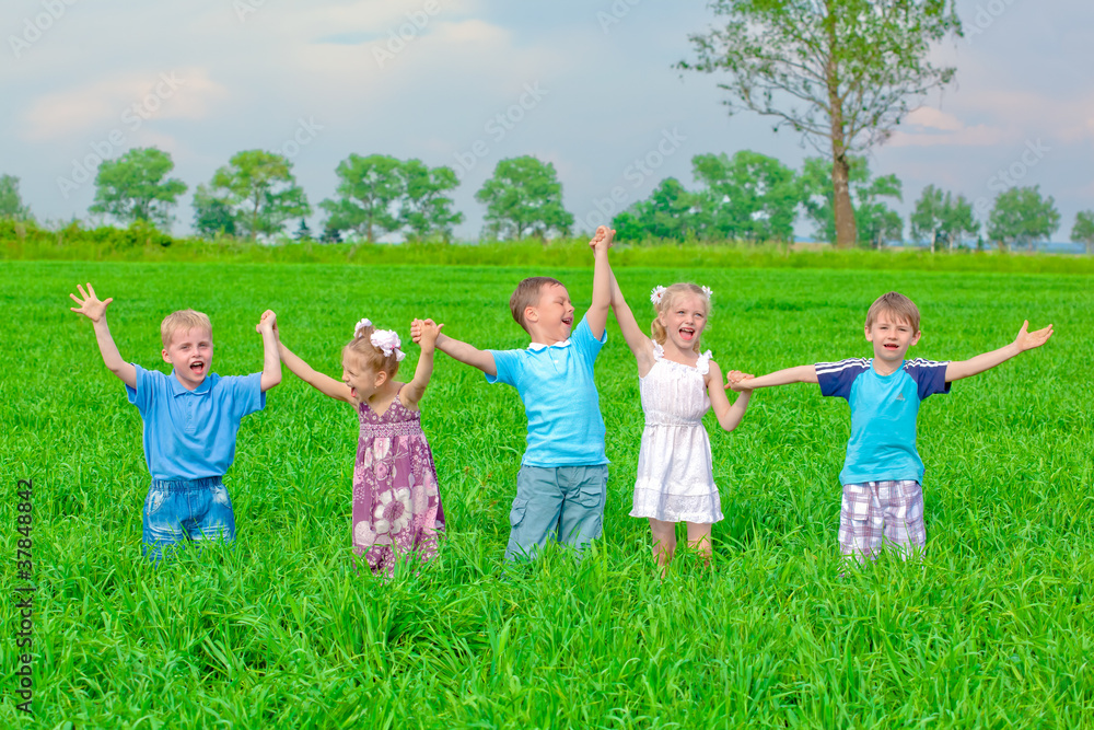 Naklejka premium Funny kids standing on grass holding hands up
