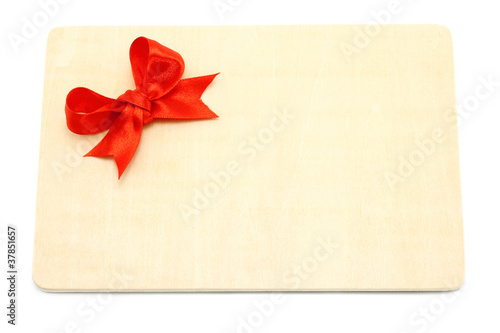 Big red holiday bow on a wooden board