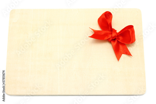 Big red holiday bow on a wooden board