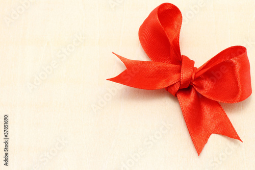 Big red holiday bow on a wooden board close-up