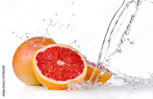 Grapefruit slice in water splash, isolated on white background