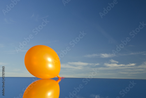 orange balloon on mirror and sky