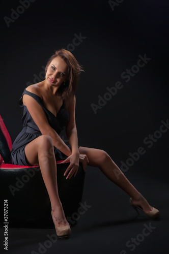 brunette girl posing in studio on dark background