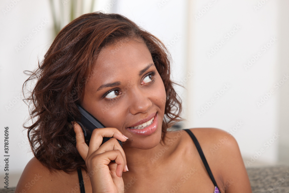 Fototapeta premium Young woman talking on the telephone