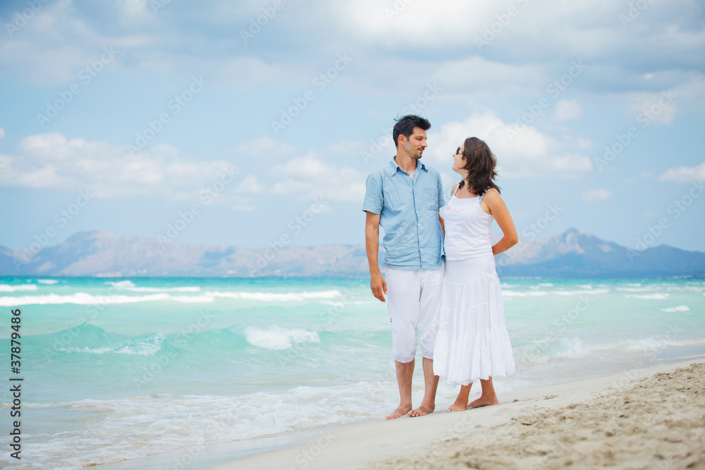 Happy young couple walking on beach Happy young couple walking on beach