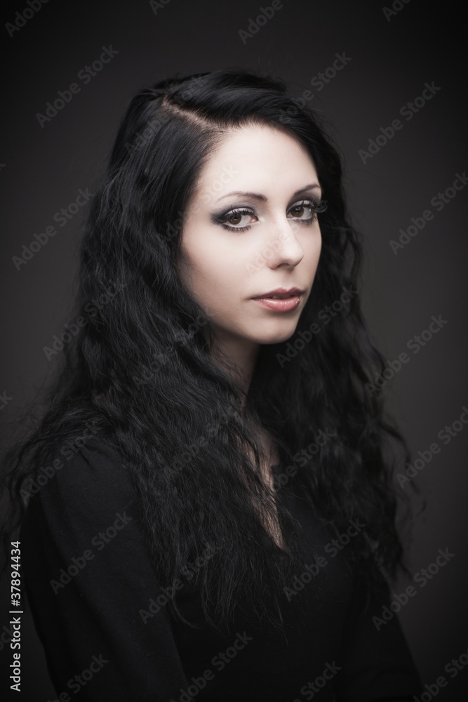 Young attractive gothic brunette woman over black