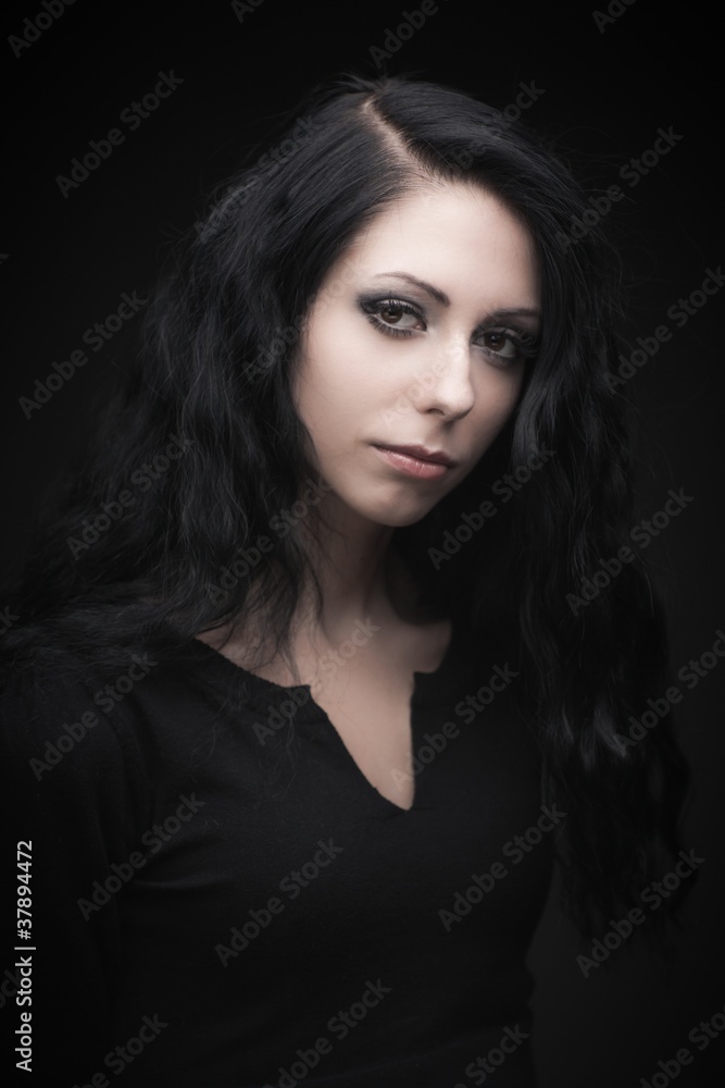 Young attractive gothic brunette woman over black