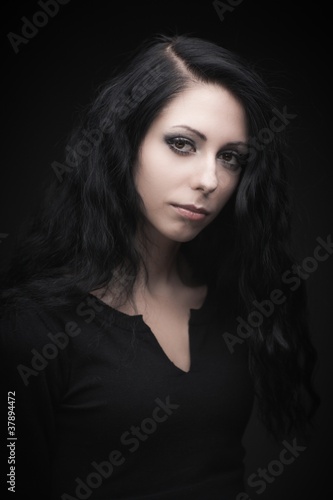 Young attractive gothic brunette woman over black