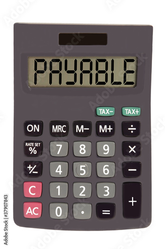 Old calculator on white background showing text "payable"