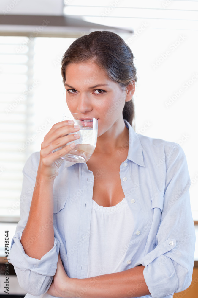 Portrait of a young woman drinking a glass of water Portrait of a young woman drinking a glass of water