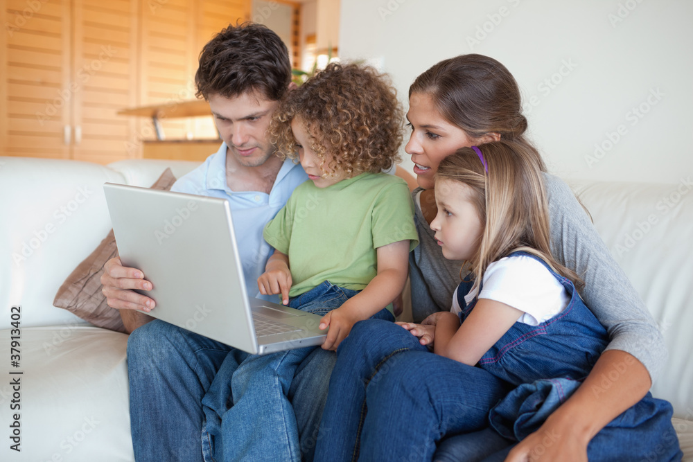 Focused family using a laptop Focused family using a laptop