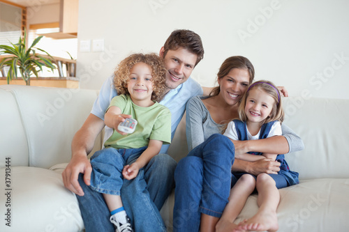 Smiling family watching TV together