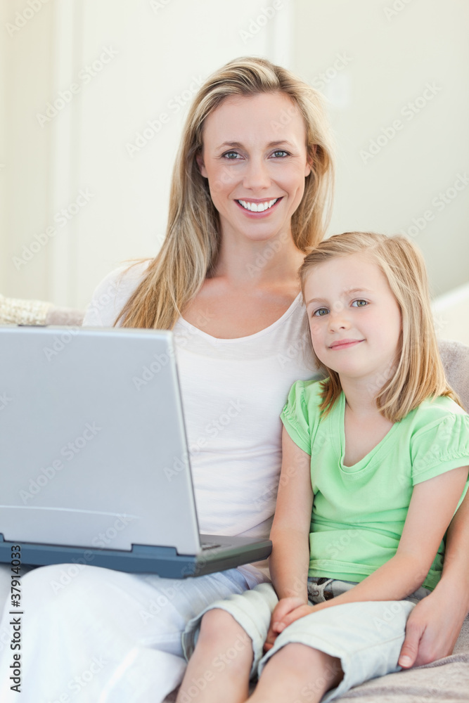 Mother and daughter with laptop on sofa Mother and daughter with laptop on sofa