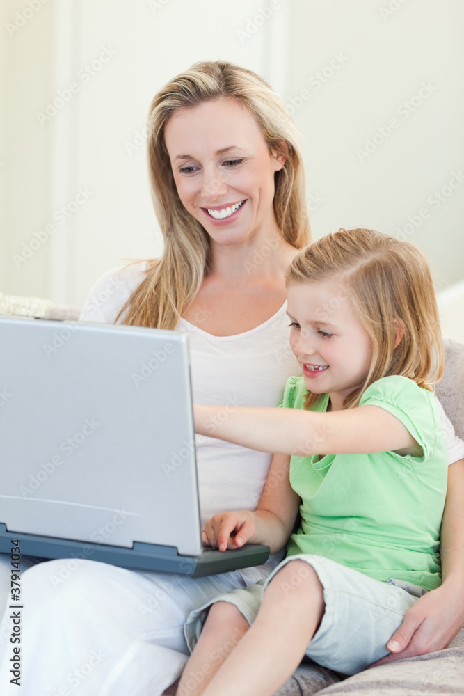 Mother and daughter with laptop on couch Mother and daughter with laptop on couch