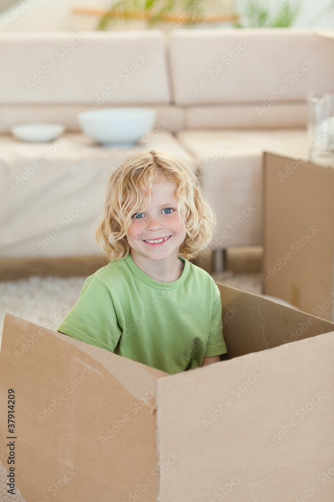 Boy hiding in cardboard box Boy hiding in cardboard box