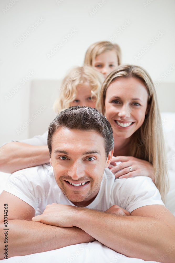 Smiling family lying on bed Smiling family lying on bed