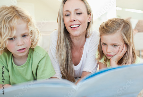 Mother reading magazine with her children