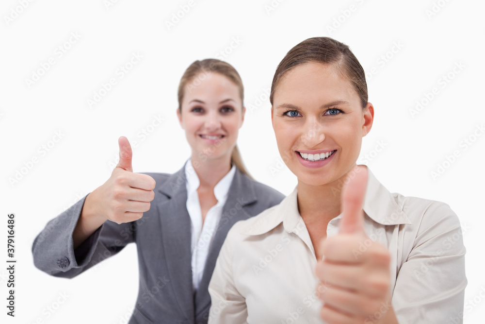 Smiling sales persons posing with the thumb up Smiling sales persons posing with the thumb up