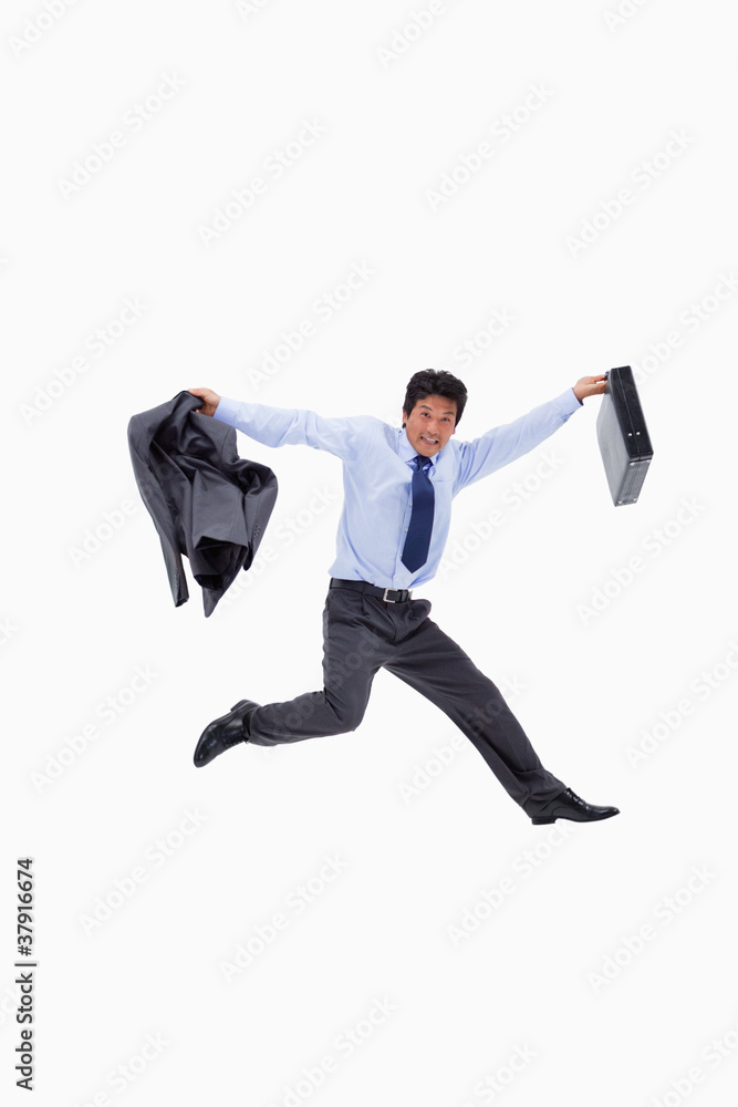 Cheerful businessman jumping while holding his jacket and a brie