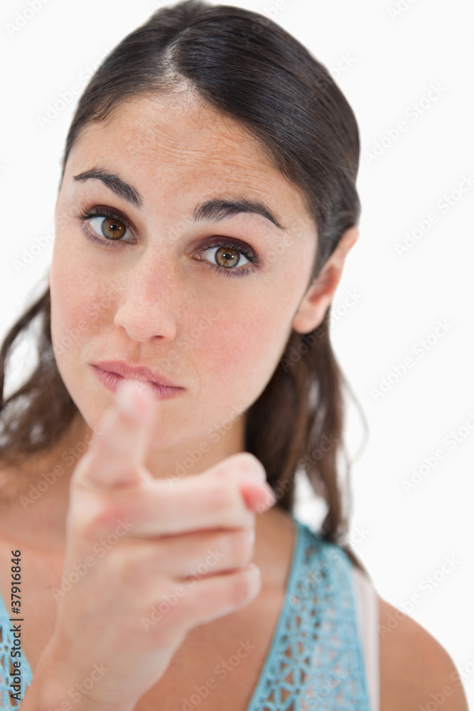 Portrait of a young woman pointing at the viewer Portrait of a young woman pointing at the viewer